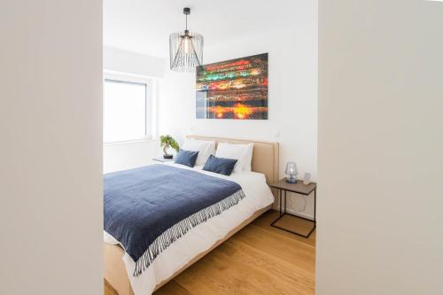 a bedroom with a bed and a painting on the wall at Hamilius Apartments City Center Luxembourg by Rentaroo in Luxembourg