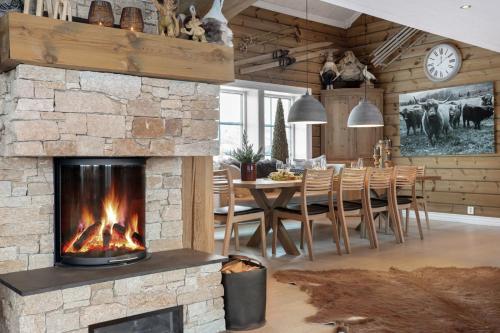 a living room with a fireplace and a dining room at Guroli - Mountain Lodge in Torvetjørn
