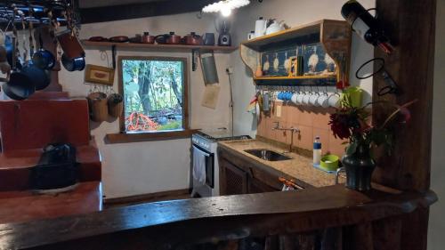 a kitchen with a counter and a sink and a window at Casa Verde-Casa de Temporada no Bichinho in Bichinho