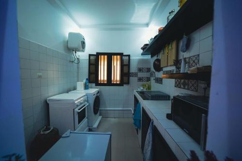 a small kitchen with a sink and a stove at Le charmant in Dakar