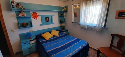 a childs bedroom with a blue bed with yellow pillows at Casa Akay in Zorita