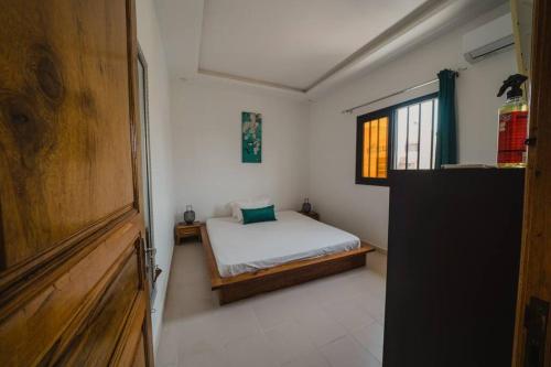 a small bedroom with a bed and a window at Le charmant in Dakar