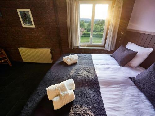 1 dormitorio con 1 cama grande y toallas. en Het mooiste uitzicht-De Oogappel, en Vijlen