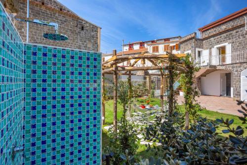 a garden with blue tiles on the side of a building at YourHome - Relais Loggia Li Galli in Massa Lubrense