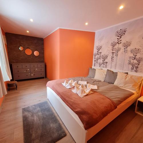 a bedroom with a large bed with orange walls at Murzeit Zweite in Murau