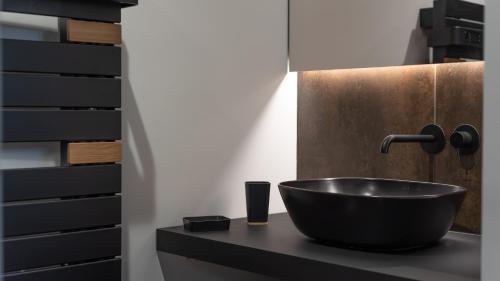 een badkamer met een zwarte wastafel op een aanrecht bij Le Ruthénois T2 avec terrasse, classé meublé de tourisme in Rodez
