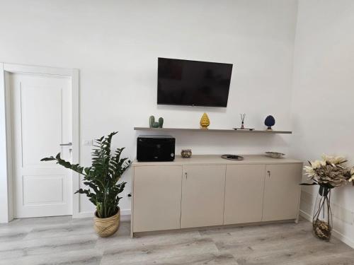 a living room with a tv on a white wall at Heart City Rooms in Catania