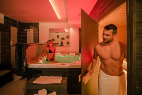 Hotel Frymburk في فريمبورك: رجل في الحمام مع امرأة في الحوض