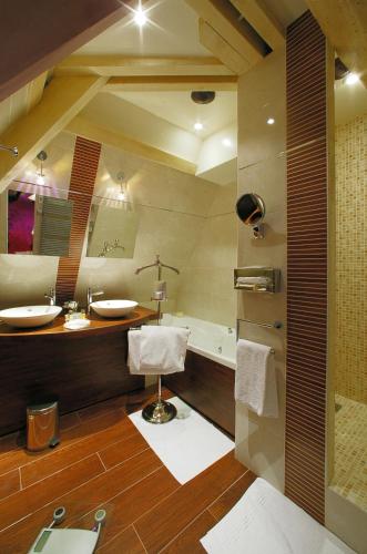 une salle de bain avec deux lavabos et une baignoire dans l'établissement Clos La Boëtie & Spa, à Sarlat-la-Canéda