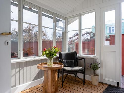 a room with a chair and a table and windows at Villa Vega in Trosa