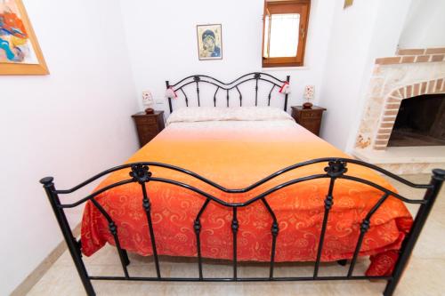 a bedroom with a bed with an orange blanket at Trulli Villa Rosa Lia in Martina Franca