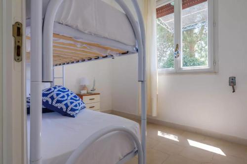 1 dormitorio con litera y ventana en Punta Prosciutto Sea View Facing the Sea With Air Conditioning, Parking And Wi-Fi, en Torre Lapillo