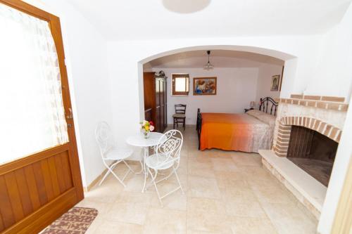 a living room with a fireplace and a bedroom at Trulli Villa Rosa Lia in Martina Franca