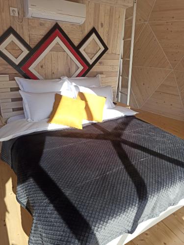 a bedroom with a large bed with yellow pillows at Honey dome in Vizhenka