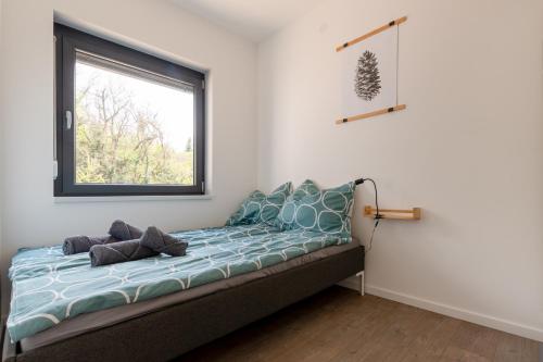 Ce lit se trouve dans un dortoir doté d'une fenêtre. dans l'établissement Tűlevél Apartman, à Siófok