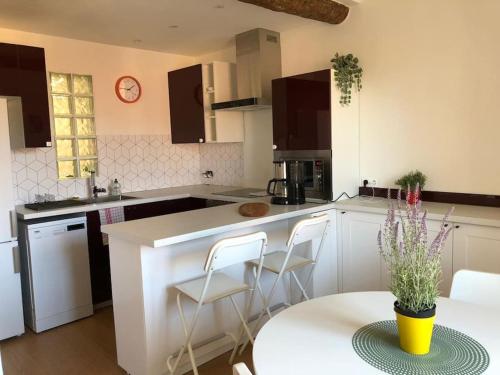 une cuisine blanche avec une table et des chaises dans l'établissement Au coeur du Vieux Nice: Charmant logement pour 4, à Nice