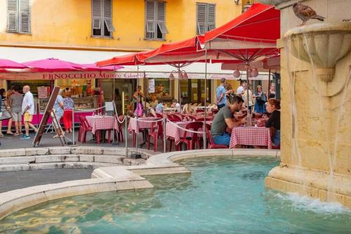 une fontaine dans une cour avec des tables dans l'établissement Au coeur du Vieux Nice: Charmant logement pour 4, à Nice