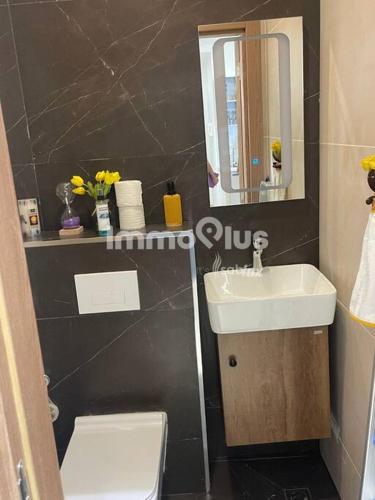 a bathroom with a sink and a toilet and a mirror at Eden Home Point E Studio Neuf in Dakar