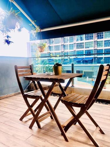 einen Holztisch und Stühle in einem Zimmer mit Fenster in der Unterkunft Dzora Vista Alam in Shah Alam