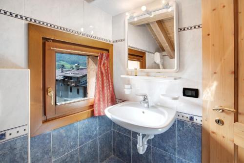 een badkamer met een wastafel en een raam bij Baita Truzz appartamento Valle in Livigno