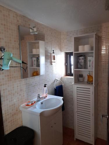 W łazience znajduje się umywalka i lustro. w obiekcie Villa Casa das Palmeiras w mieście Charneca