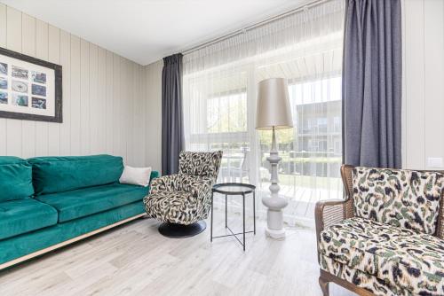 a living room with a green couch and two chairs at Ramios bitės in Palanga