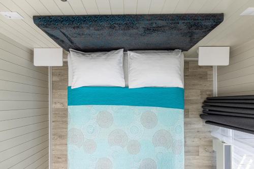 a bed with two pillows on it in a room at Ramios bitės in Palanga