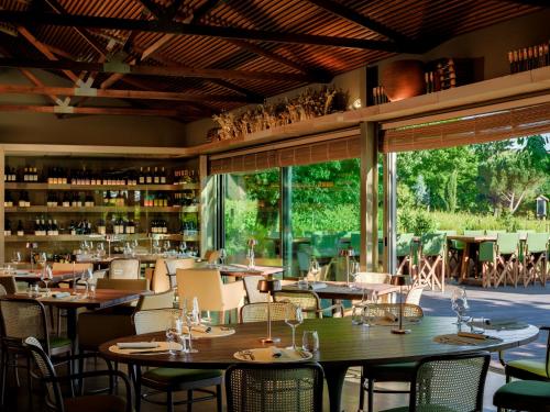 a dining room with tables and chairs and windows at Lavandeira Douro Nature & Wellness in Baião