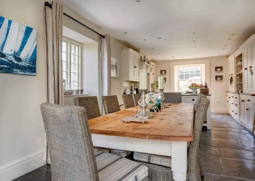 a kitchen and dining room with a wooden table and chairs at Vine House in Salcombe