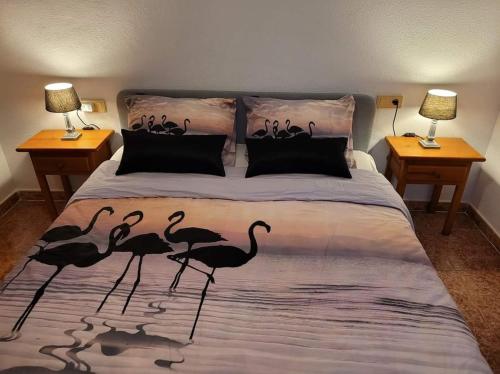 a bedroom with a bed with a group of flamingos on it at Casa Danas in Torrevieja