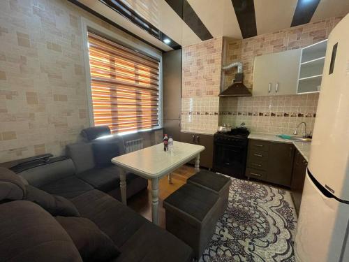 a kitchen and a living room with a table and a couch at Comfortable apartments complex at Nova Garden near Disney Land in Tashkent