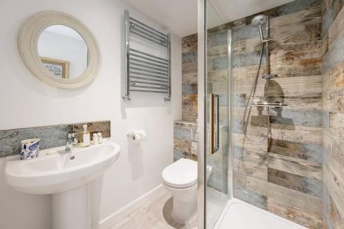 een badkamer met een toilet, een wastafel en een douche bij Treetops in Salcombe