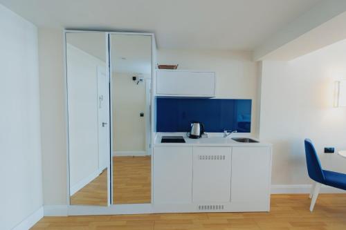 uma cozinha com armários brancos e uma parede de vidro em Orbi City Luxury Towers em Batumi