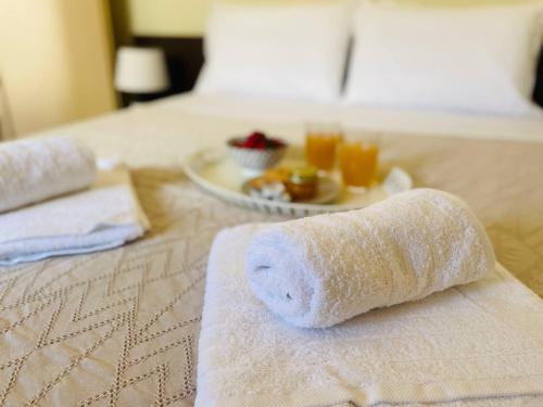 uma toalha enrolada numa cama com um prato de comida em Cozy Nest - 2min To Beach, 6min Walk To Old Town em Chania Town