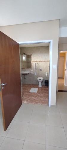 an empty bathroom with a toilet and a sink at Urunday Apart Hotel in Posadas