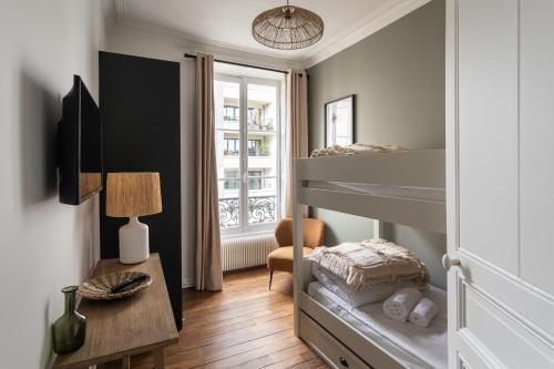 雷恩的住宿－Le Goya - Appartement 4 chambres centre ville de Rennes，一间小卧室,配有双层床和一张桌子
