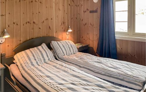 1 cama no hecha en un dormitorio con paredes de madera en Beautiful Home In Fl With Sauna, en Flå