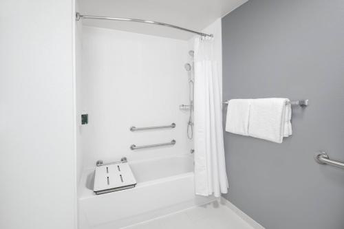 La salle de bains est pourvue d'une douche blanche avec une porte en verre. dans l'établissement Courtyard by Marriott Augusta, à Augusta