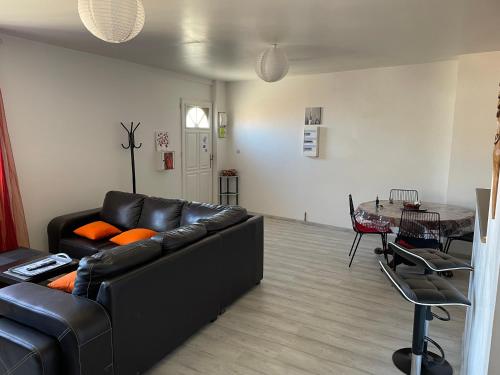 un salon avec un canapé noir et une table dans l'établissement L’escapade, à Catllar