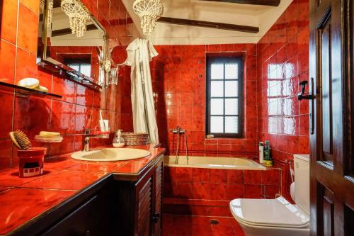 Sonia Rustic Mansion - 5bd 30 Sec Walk To Beach في أييوي أبوستولوي: حمام ذو بلاط احمر مع حوض استحمام ومغسلة
