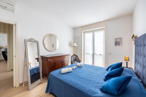 ein Schlafzimmer mit einem blauen Bett mit blauen Kissen und einem Spiegel in der Unterkunft [BOCCONI] Elegante Appartamento con WIFI in Mailand