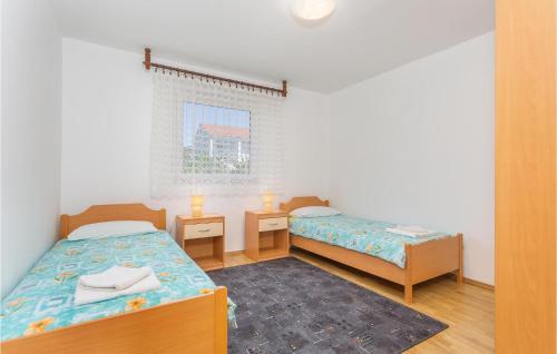 um pequeno quarto com 2 camas e uma janela em Lovely Apartment In Krk With Kitchen em Brzac