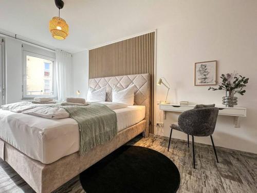une chambre avec un lit, un bureau et une chaise dans l'établissement Appartio - modern - luxuriös - Netflix - Flughafennähe - 55 qm, à Leura
