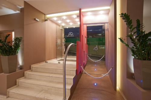 un couloir avec des escaliers et une porte coulissante en verre. dans l'établissement Nidimos Hotel, à Delphes