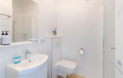 a white bathroom with a toilet and a sink at Amazing Home In Jaroslawiec With House A Panoramic View in Jarosławiec