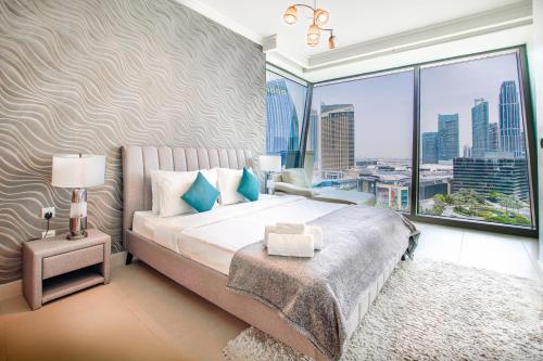 sypialnia z dużym łóżkiem i dużym oknem w obiekcie Burj Vista 08 3BR Burj & Fountain View w Dubaju