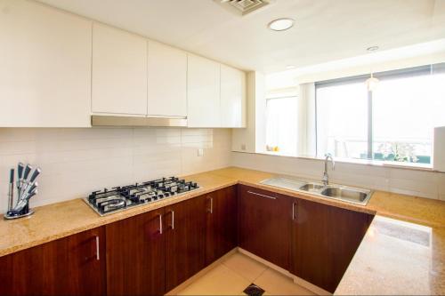a kitchen with wooden cabinets and a sink and a stove at Burj Vista 08 3BR Burj & Fountain View in Dubai