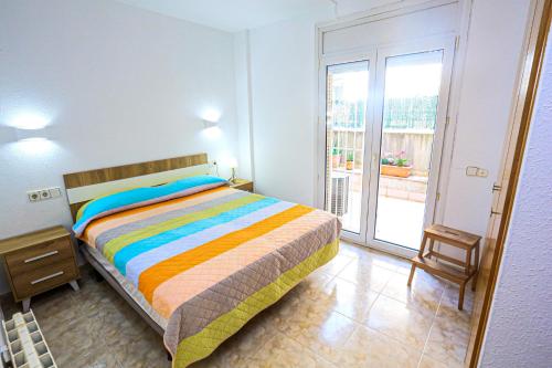 1 dormitorio con cama y ventana grande en Tramuntana Roya Bjs ONLY FAMILLIES, en Cambrils