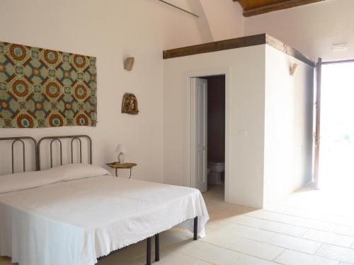 une chambre avec un lit et un tableau au mur dans l'établissement CASINO de VITI - Dimora storica con piscina, à Vaste