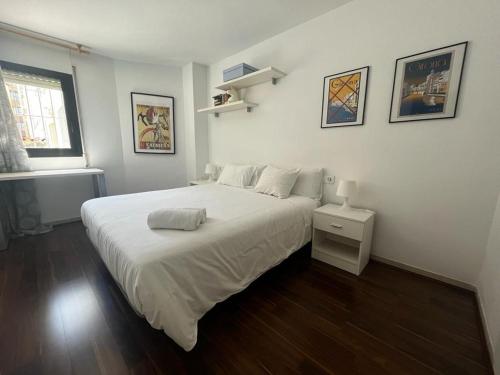 a white bedroom with a large bed and a window at Apartamento para 4 con terraza privada en el centro in Girona